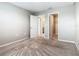 A bright bedroom with neutral walls, plush carpeting, and doorways leading to a closet and bathroom at 242 White Heron Way, St Cloud, FL 34772