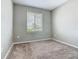 A cozy bedroom with a window and neutral carpeting at 242 White Heron Way, St Cloud, FL 34772