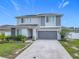 Charming home showcasing a two-car garage, well-kept lawn, and contemporary architectural details at 242 White Heron Way, St Cloud, FL 34772
