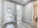 Bright foyer with hardwood floors, a modern front door, and a view into adjacent rooms and powder room at 242 White Heron Way, St Cloud, FL 34772
