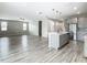 Open-concept kitchen features an island, stainless steel appliances, pendant lighting, and a view into the living area at 242 White Heron Way, St Cloud, FL 34772