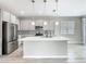 Kitchen has a large island, quartz countertop, stainless steel appliances, mosaic backsplash, and modern lighting at 242 White Heron Way, St Cloud, FL 34772