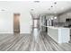 Bright kitchen and entryway with stainless steel appliances, a large island with quartz countertop, and ample storage space at 242 White Heron Way, St Cloud, FL 34772