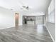 Open-concept living room showcasing wood-look floors and a seamless transition to a modern kitchen at 242 White Heron Way, St Cloud, FL 34772