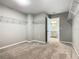 Walk-in closet with shelves and carpeted floor, leading to a well-lit bathroom at 242 White Heron Way, St Cloud, FL 34772