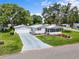 Aerial view of a charming home with a well-manicured lawn and a long driveway at 25333 Casa Del Lago Ln, Leesburg, FL 34748