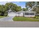 Well-maintained single-story home with an attached garage and charming front porch at 25333 Casa Del Lago Ln, Leesburg, FL 34748