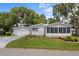 Charming home featuring a well-manicured front yard and a lovely screened-in porch for relaxing outdoors at 25333 Casa Del Lago Ln, Leesburg, FL 34748