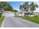 Inviting home with a spacious driveway leading to a garage, complemented by a charming screened-in porch at 25333 Casa Del Lago Ln, Leesburg, FL 34748