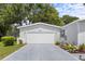 A well maintained garage and driveway with ample space for parking, surrounded by green grass at 25333 Casa Del Lago Ln, Leesburg, FL 34748