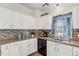 A kitchen area showcasing granite counters, mosaic tile backsplash, and white cabinets at 25333 Casa Del Lago Ln, Leesburg, FL 34748
