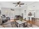 Comfortable living room with a ceiling fan and view of the modern kitchen with white cabinets at 25333 Casa Del Lago Ln, Leesburg, FL 34748