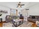 Bright living room showcasing a ceiling fan, comfortable seating, and sliding glass doors leading to an outdoor space at 25333 Casa Del Lago Ln, Leesburg, FL 34748