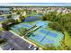 Aerial view of community tennis and basketball courts surrounded by lush greenery and ponds at 2918 Rodrick Cir, Orlando, FL 32824