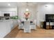 Dining area with round wood table, white chairs, modern light fixture, and adjacent kitchen at 2918 Rodrick Cir, Orlando, FL 32824