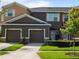 Townhouse exterior featuring attached garages, neat landscaping, and coordinated color schemes under a bright sky at 2918 Rodrick Cir, Orlando, FL 32824