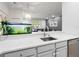 Modern kitchen with stainless steel dishwasher, quartz countertops, a stylish faucet, and a view into the living room at 2918 Rodrick Cir, Orlando, FL 32824