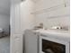 Well-lit laundry room with a washer, dryer, and wire shelving at 2918 Rodrick Cir, Orlando, FL 32824