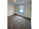 Carpeted bedroom featuring a window with blinds and modern trim at 3213 Energy Dr, Kissimmee, FL 34747
