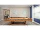 Spacious game room features a billiard table, wood floors, and natural light at 345 S Sunset Ave, Mascotte, FL 34753