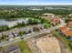 Aerial view of a community with well-maintained homes, lush greenery, and a nearby lake at 363 Miro Dr, Davenport, FL 33837