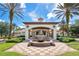Elegant clubhouse entrance featuring a water fountain, clock tower, and palm trees in a meticulously landscaped setting at 363 Miro Dr, Davenport, FL 33837