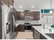 Sleek kitchen features stainless steel appliances, dark cabinetry, a center island, and contemporary design elements at 363 Miro Dr, Davenport, FL 33837