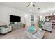 Bright open-concept living room with neutral furniture, stylish decor, and seamless flow into the dining and kitchen areas at 363 Miro Dr, Davenport, FL 33837