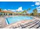 Large community pool with tables and plenty of chairs, surrounded by palm trees and lush landscaping at 363 Miro Dr, Davenport, FL 33837
