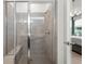Modern glass enclosed shower with bench seating and stylish tile surround; main bedroom in the background at 363 Miro Dr, Davenport, FL 33837