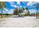 Sandy volleyball court by the lake for outdoor recreation, framed by scenic water and lush greenery at 363 Miro Dr, Davenport, FL 33837