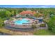 Aerial view of clubhouse with a pool, blue canopies, seating, and lounge chairs at 381 Cabello Dr, Davenport, FL 33837