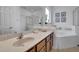 The bathroom boasts a double-mirrored sink, a shower, and a tub for a luxurious and functional experience at 381 Cabello Dr, Davenport, FL 33837