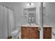 Bright bathroom featuring a wood vanity, toilet, shower/tub, and decorative wall art at 381 Cabello Dr, Davenport, FL 33837