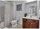 Bright bathroom with wood cabinets, shower and vanity with a sink at 381 Cabello Dr, Davenport, FL 33837