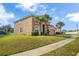Side view of a tan two-story home with a red tile roof and tropical palm tree landscaping at 381 Cabello Dr, Davenport, FL 33837