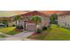 Two-story tan home with red tile roof, palm trees, and a well-maintained lawn at 381 Cabello Dr, Davenport, FL 33837