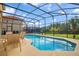 A screened-in pool with outdoor seating offers a relaxing outdoor space at 381 Cabello Dr, Davenport, FL 33837