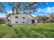 Back view of two-story home with large, grassy yard, patio, and sliding glass doors at 40140 Swift Rd, Eustis, FL 32736
