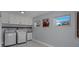Well-lit laundry room with white cabinets, a sink, and modern washer and dryer units at 40140 Swift Rd, Eustis, FL 32736