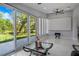 Bright living room with sliding glass doors leading to a scenic backyard, white tile floors and a ceiling fan at 40140 Swift Rd, Eustis, FL 32736
