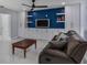 Stylish living room with a blue accent wall, built-in shelving, and a comfortable leather sofa at 40140 Swift Rd, Eustis, FL 32736