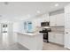 Contemporary kitchen boasting white cabinets, stainless steel appliances, and an island with breakfast bar at 4709 Jasmine Cir, Leesburg, FL 34748