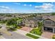 Aerial view showcases this lovely home with its brick driveway, three-car garage, and well-manicured lawn in a quiet neighborhood at 5182 Appenine E Loop, St Cloud, FL 34771