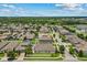 An aerial view reveals a lush backyard with a private pool, nestled amongst well-kept homes and verdant trees at 5182 Appenine E Loop, St Cloud, FL 34771