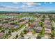 Expansive aerial view of a residential community featuring well-maintained homes, serene lake, and lush green landscaping at 5182 Appenine E Loop, St Cloud, FL 34771