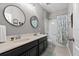 Well lit bathroom with double sink vanity and shower-tub combo at 5182 Appenine E Loop, St Cloud, FL 34771