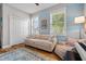 Cozy bedroom with a sofa, accent wall, and wood-look flooring at 5182 Appenine E Loop, St Cloud, FL 34771