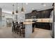 Modern kitchen with dark cabinetry, an island with barstool seating, stainless steel appliances, and pendant lighting at 5182 Appenine E Loop, St Cloud, FL 34771
