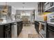 Modern kitchen featuring dark cabinets, stainless steel appliances, and a view into the dining area at 5182 Appenine E Loop, St Cloud, FL 34771